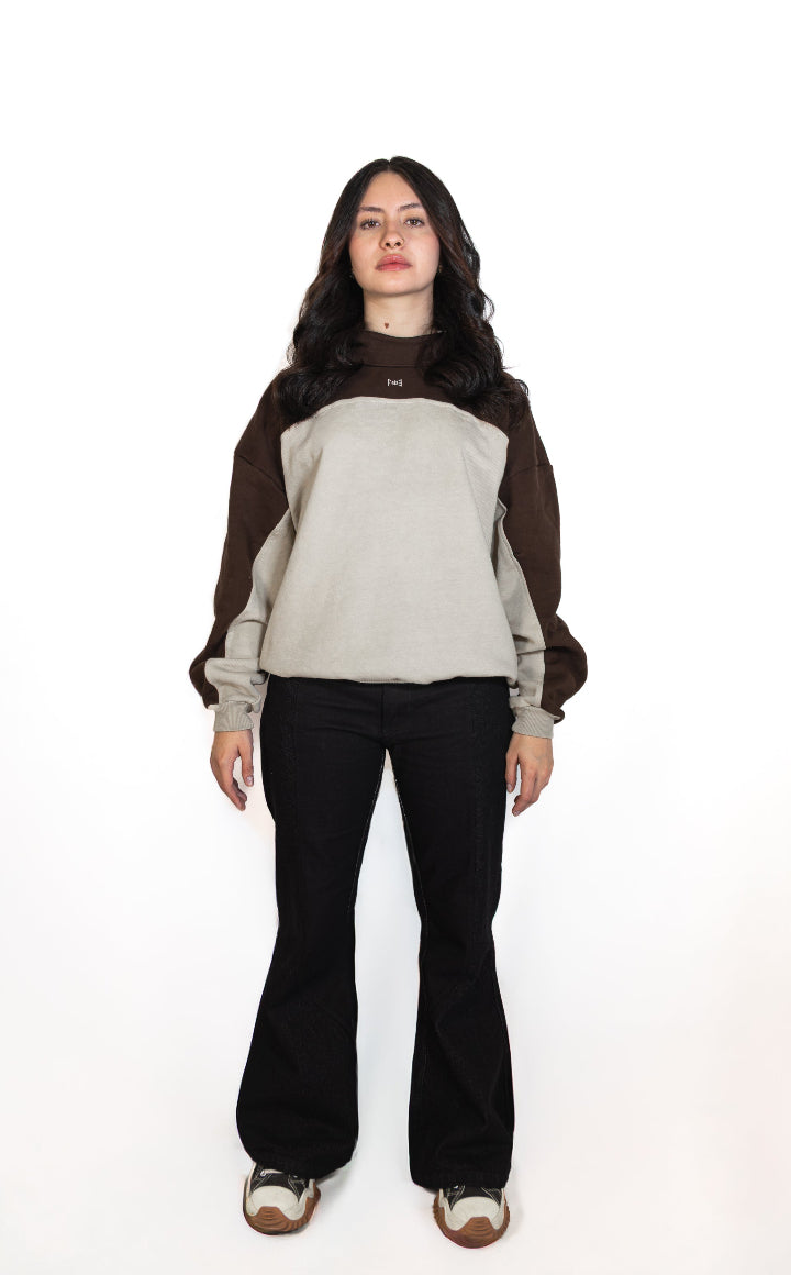 Woman wearing a two-tone sweater and black pants on a white background
