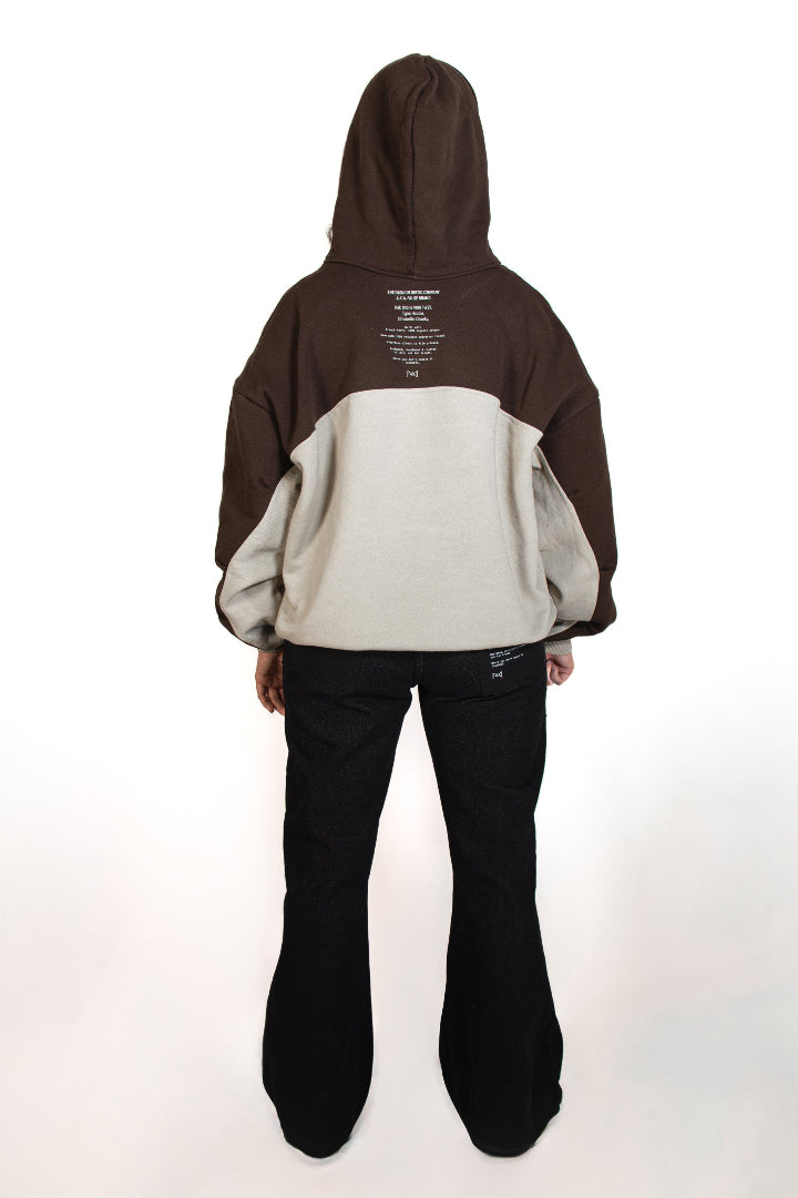 Person wearing a two-tone hoodie and black pants on a white background