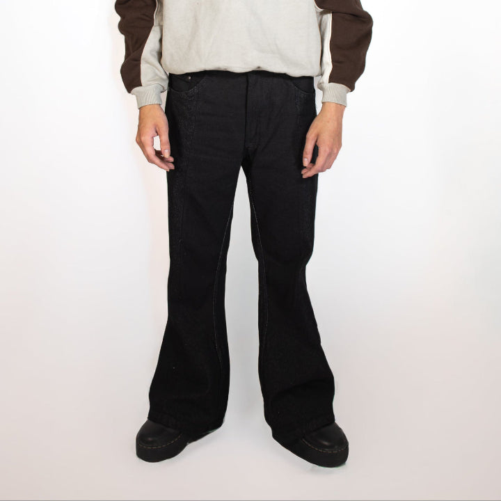 Person wearing a brown and beige hoodie with black pants on a white background