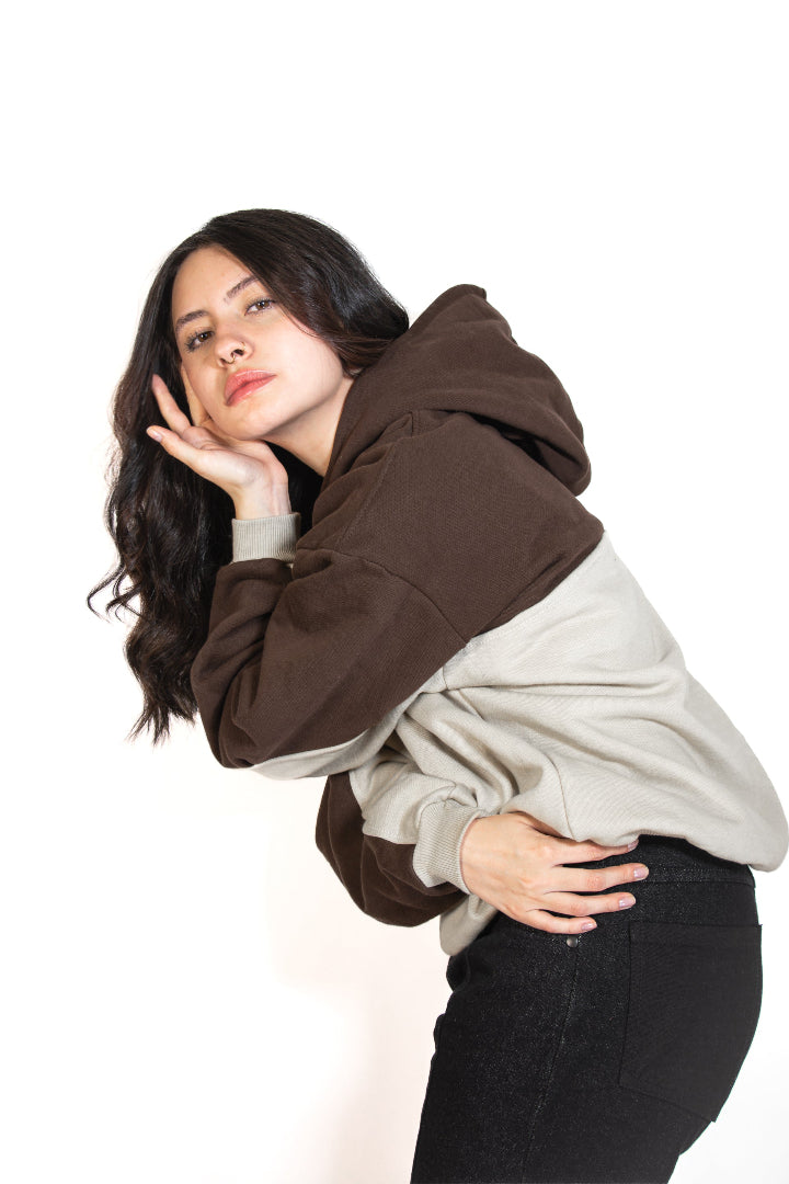 Woman wearing a brown and beige hoodie on a white background