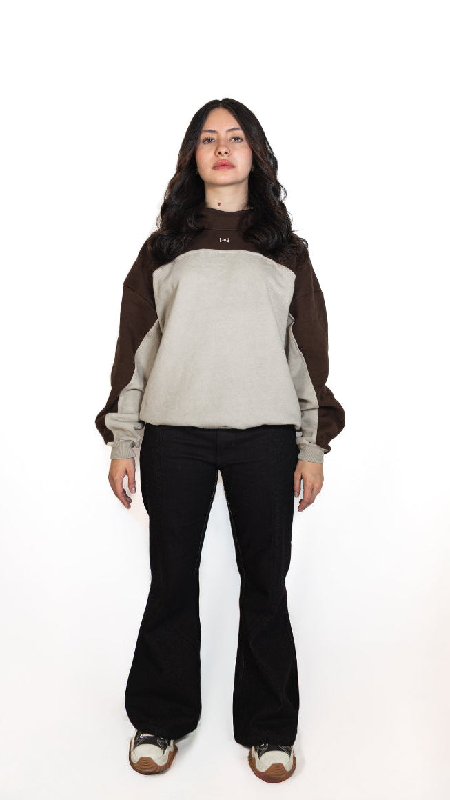 Woman wearing a two-tone sweater and black pants on a white background