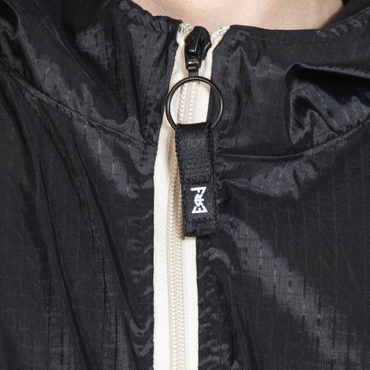 Close-up of a black jacket with a zipper and brand logo.