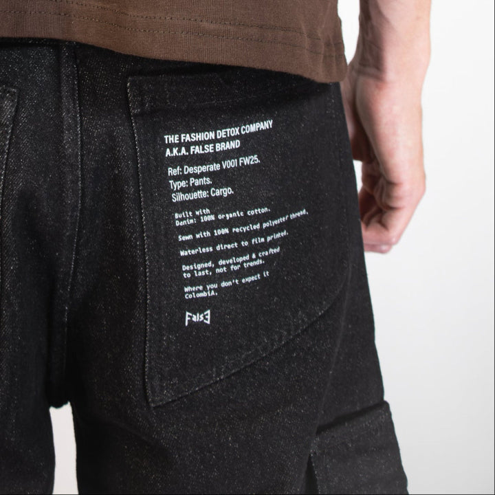 Brown t-shirt with white text on the back worn by a person, on a plain background