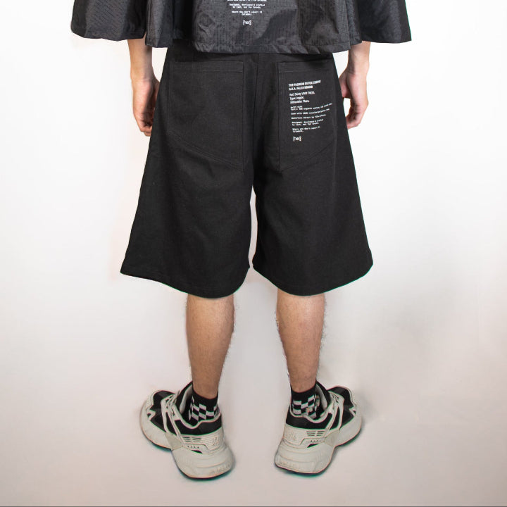 Person wearing a black raincoat and shorts on a white background