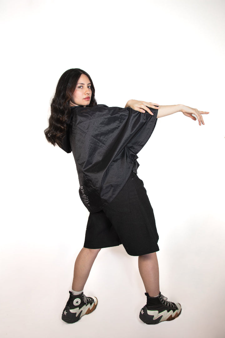 Person wearing a black outfit with a hood on a white background